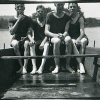 Ralph and three male friends in swimsuits on a small boat.