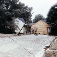 A house, moved by flood waters, sits in the middle of a street