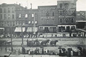 Horse drawn fire tankers in parade with onlookers