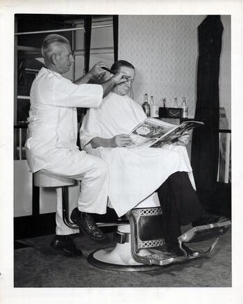 Barber Mike Salerno in his shop cutting hair (1952)