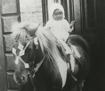Child sits on a pony