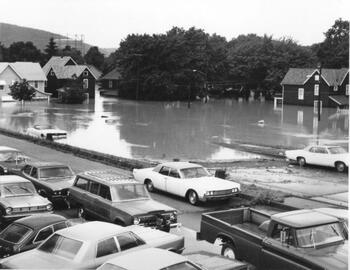 Cars parked along a street just above a flooded neighborhood on Corning's north side