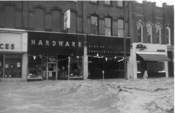 A Hardware store on Corning's Market street with water running up to the front door
