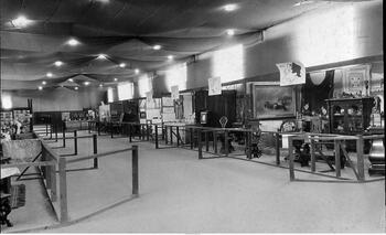 Exhibit booths in right aisle at the Rochester Homelands Exhibition, April 10-19, 1920, on the grounds of Exposition Park in Rochester, NY.