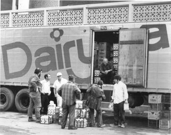 Men unloading crates of milk from a Dairyland truck at the Corning Hospital